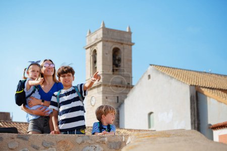 Photo for Mother stand on Peniscola viewpoint with kids overlooking panorama of town on their summer vacation trip - Royalty Free Image
