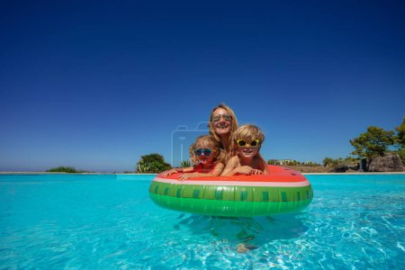 Photo for Mother and two children sharing a watermelon themed inflatable ring - Royalty Free Image