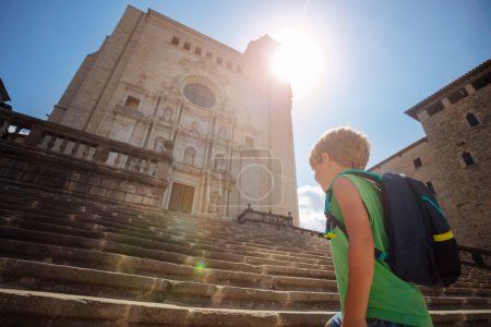 Foto de Dos lindos pequeños turistas suben las famosas escaleras de la Catedral de Girona durante su recorrido por España - Imagen libre de derechos