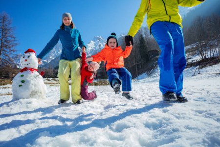 Foto de Familia feliz en traje de invierno brillante disfrutar de las vacaciones de Navidad y divertirse en las montañas nevadas - Imagen libre de derechos