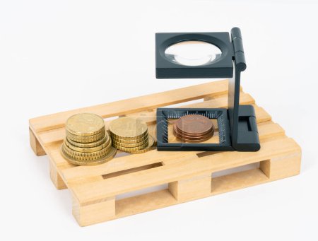 Photo for Coins and a magnifying glass on a pallet - Royalty Free Image
