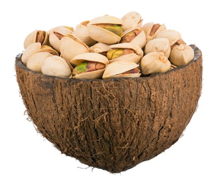 Photo for Pistachios in a bowl. Close-up of pistachio nuts in brown coconut bowl. Closeup of some roasted pistachio in bowl over white background. - Royalty Free Image