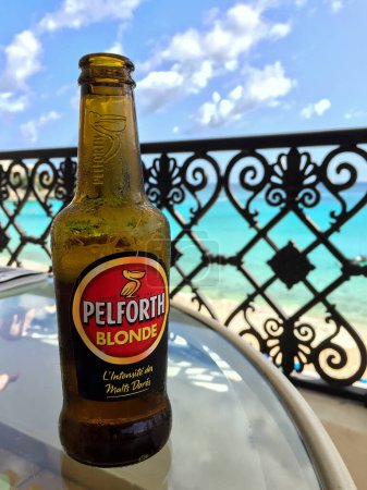 Téléchargez les photos : ST.MAARTEEN, CARIBBEAN ISLAND - AUGUST 8, 2015: Pelforth Blonde beer outdoor with blue sky and ocean - en image libre de droit