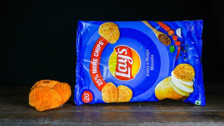 Photo for NORWALK, CT, USA - FEBRUARY 1, 2024: India's magic masala chips from Lays package on wooden table and black background - Royalty Free Image