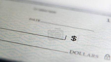 Vista de primer plano de un cheque en blanco en un escritorio listo para que alguien llene los detalles necesarios para una transacción financiera