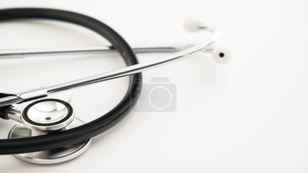 A stethoscope, indicative of the medical profession, is laid out on a pristine white background