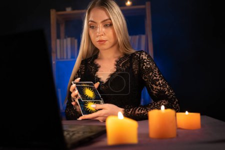 Téléchargez les photos : Lecteur de carte Tarot psychique sur ordinateur portable tout en ayant une session en ligne, espace de copie - en image libre de droit