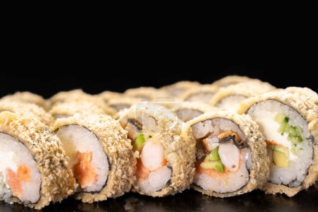 Hot smażone Sushi Roll z krewetek, łosoś, ogórek i ser Philadelphia na czarnym tle. Koncepcja menu sushi. Japońskie jedzenie. Zamknij się.