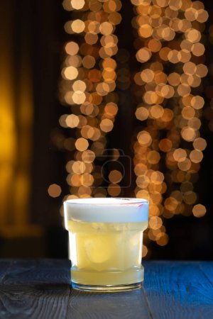 Foto de Bebida de cóctel whiskey sour en el mostrador de bar de madera en el club nocturno o restaurante. - Imagen libre de derechos