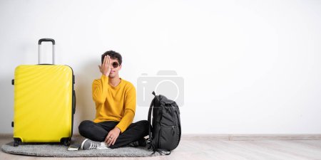 Photo for Smiling young man traveler, with eye, closed by hand, covering part of her face, over white background, with blank copy space area for slogan or text message. Banner - Royalty Free Image
