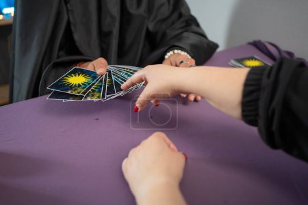 Téléchargez les photos : Fortune teller man reading tarot cards having a session with a client, close-up - en image libre de droit