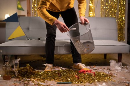 Foto de Christmas cleaning after. Cleaning broken Christmas decorations after party at home. Concept of cleaning after holiday, clean up the mess. Copy space - Imagen libre de derechos