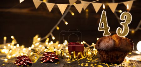 Téléchargez les photos : 43th birthday. Delicious cupcake with number forty-three shaped candles on wooden background, space for text. Copy space - en image libre de droit