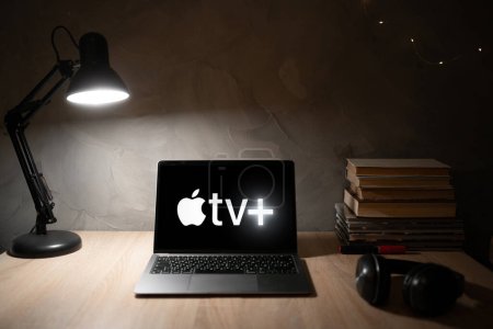 Photo for Ukraine, Odessa January 9, 2023: Table with laptop and Apple TV plus logo on the screen. streaming service watching videos online in the evening at home. - Royalty Free Image