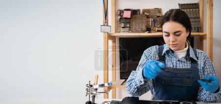 Photo for A woman disassembles a laptop. Laptop disassembling in repair shop, close-up. Computer service and repair concept. Banner. Copy space - Royalty Free Image