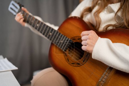 Photo for Woman playing acoustic guitar at home, female hands with guitar, close up. - Royalty Free Image