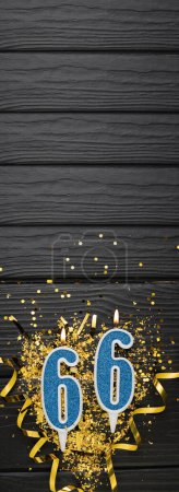 Foto de Vela de celebración azul número 66 y confeti dorado sobre fondo de madera oscura. Tarjeta de cumpleaños 66. Aniversario y concepto de cumpleaños. Banner vertical. Copiar espacio - Imagen libre de derechos