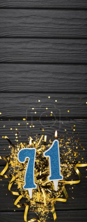 Téléchargez les photos : Bougie de célébration bleue numéro 71 et confettis dorés sur fond bois foncé. 71ème carte d'anniversaire. Concept anniversaire et anniversaire. Bannière verticale. Espace de copie - en image libre de droit