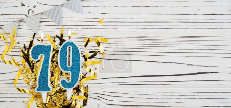 Photo for Number 79 blue celebration candle on white wooden background with golden foil. Copy space. Banner - Royalty Free Image