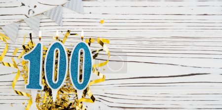 Blaue Kerze Zahl, Zahl hundert. Geburtstagsgrußkarte mit der Aufschrift 100. Jubiläumskonzept. Ansicht von oben. Ziffer auf weißem Holzgrund. Ziffernzahl, Feier-Ereignis. Kopierraum