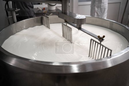 Processus de fabrication de produits laitiers dans l'usine laitière moderne. Préparation du lait pour le fromage, pasteurisation dans de grandes cuves. Espace de copie