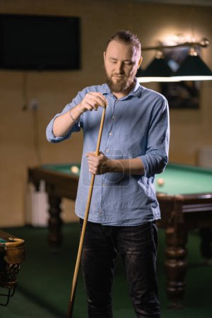 Photo for Portrait of a man preparing a billiard cue. - Royalty Free Image