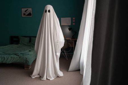 Photo for Ghost covered with a white ghost sheet on a bedroom in new house. Halloween Concept - Royalty Free Image