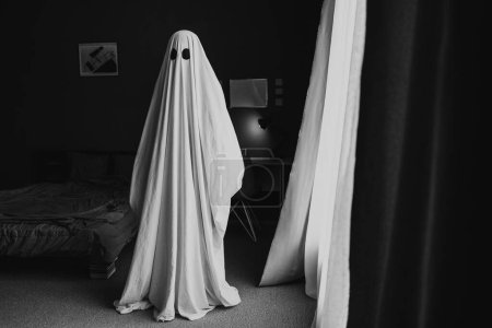 Photo for Black and white photo of ghost covered with a white ghost sheet in the room at home. Halloween Concept. Copy space - Royalty Free Image