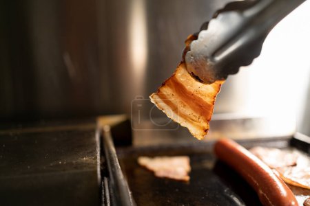 Photo for Grilled hot dog and bacon in a street food cafe. Close-up. Copy space - Royalty Free Image
