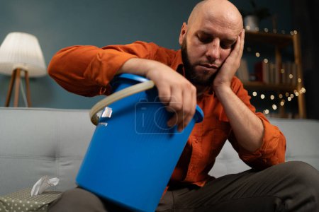 Foto de Hombre enfermo de estómago, náuseas y vómitos sentado en casa. Copiar espacio - Imagen libre de derechos