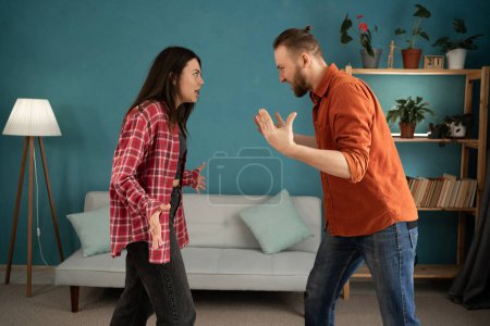 Junges Paar streitet und kämpft zu Hause. Häusliche Gewalt und emotionaler Missbrauch Szene, in der sich Frau und Mann im Wohnzimmer gegenseitig anschreien. Kopierraum