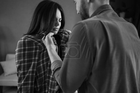 Photo for Male attacks woman. Domestic violence concept. Angry aggressive husband grabbed his wife, scared woman. Copy space. Black and white - Royalty Free Image
