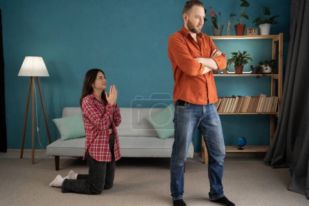 Photo for A repentant wife asking forgiveness from her offended husband after infidelity or a quarrel. Family relationships concept and problems. Copy space - Royalty Free Image