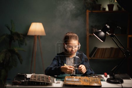 Photo for Female student uses soldering iron. She is repairing computer. Hardware engineering, technology and science concept - Royalty Free Image