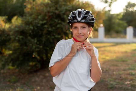 Téléchargez les photos : Fille motard portant un casque de vélo de protection, gros plan. Enfants, vélo et protection contre les blessures. Concept sportif - en image libre de droit