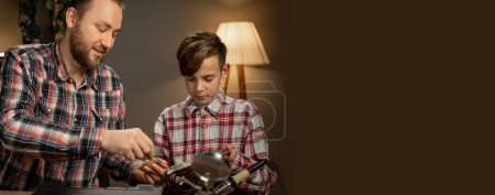 Photo for Father and son disassemble a laptop and repair the motherboard using a screwdriver. Banner. Copy space - Royalty Free Image