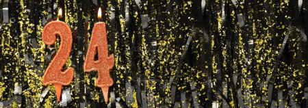 Burning red birthday candles on glitter tinsel background, number 24. Banner. Copy space
