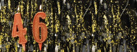 Burning red birthday candles on glitter tinsel background, number 46. Banner. Copy space