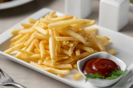 Photo for Plate of french fries potatoes served with ketchup on white plate. Unhealthy food concept - Royalty Free Image