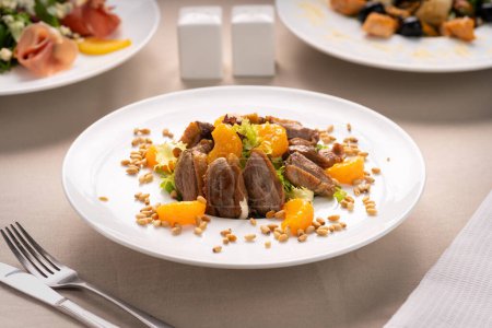 Healthy salad with duck breast, orange and vegetables. Duck meat with crispy pine nuts. Copy space