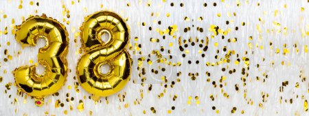 Golden foil balloon number, figure thirty-eight on white with confetti background. 38th birthday card. Anniversary concept. birthday, new year celebration. banner, copy space.
