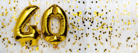 Golden foil balloon number, figure forty on white with confetti background. 40th birthday card. Anniversary concept. birthday, new year celebration. banner, copy space.