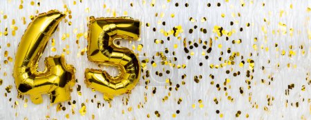 Goldfolie Luftballon-Zahl, Figur fünfundvierzig auf weiß mit Konfetti-Hintergrund. 45. Geburtstagskarte. Jubiläumskonzept. Geburtstag, Neujahrsfeier. Banner, Kopierraum.