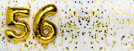 Golden foil balloon number, figure fifty-six on white with confetti background. 56th birthday card. Anniversary concept. birthday, new year celebration. banner, copy space.