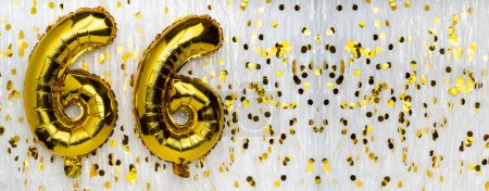Goldene Luftballon-Nummer, Figur sechsundsechzig auf weißem Grund mit Konfetti-Hintergrund. 66. Geburtstag. Jubiläumskonzept. Geburtstag, Neujahrsfeier. Banner, Kopierraum.