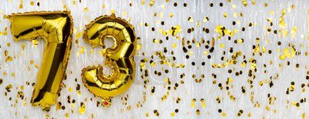 Golden foil balloon number, figure seventy-three on white with confetti background. 73th birthday card. Anniversary concept. birthday celebration. banner