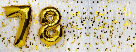 Golden foil balloon number, figure seventy-eight on white with confetti background. 78th birthday card. Anniversary concept. birthday celebration. banner