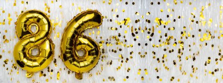 Gold foil balloon number, digit eighty-six. Birthday greeting card with inscription 86. Anniversary celebration. Banner. Golden numeral, white background. Numerical digit. Copy space