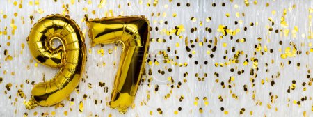Gold foil balloon number, digit ninety-seven. Birthday greeting card with inscription 97. Anniversary celebration. Banner. Golden numeral, white background. Numerical digit. Copy space
