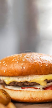 Cheeseburger or burger on a light background, fast food restaurant concept. Banner. Vertical view